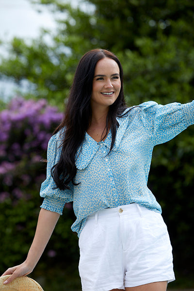 Model wearing a pale blue print blouse with oversized collar