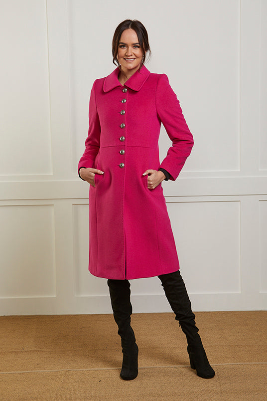 Women's winter coat in vibrant pink cashmere and wool blend. The coat is single breasted and has 7 military style buttons to the front.